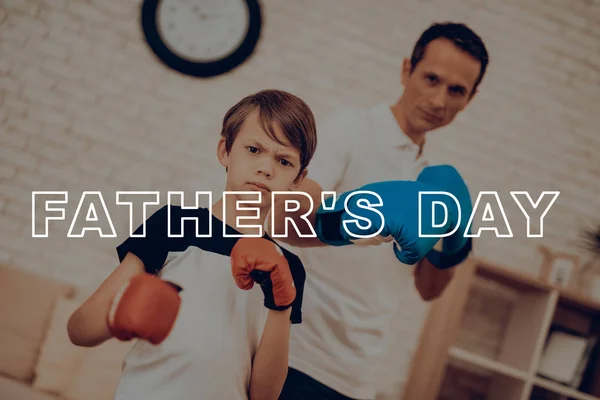 Father And Son Boxing Training. Sports Family. Healthy Lifestyle. Active Holiday. Gym Clothes. Working Out At Home. Fight Gloves. Punch Training. Repeating Exercises. Camera Staring.