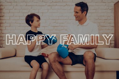 Oğlun yardımcı bir eldiven giymek baba. Spor aile. Sağlıklı bir yaşam tarzı. Aktif tatil. Spor kıyafetler. Evde çalışma dışarı. . Eğitim gün kavramı. Boks ekipman. Dövüş için hazır.