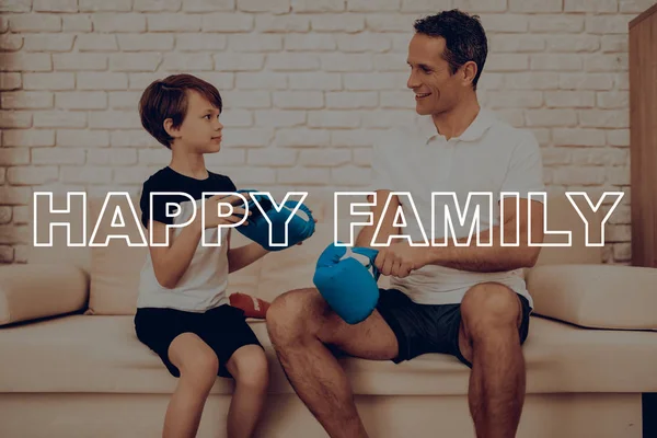 Oğlun yardımcı bir eldiven giymek baba. Spor aile. Sağlıklı bir yaşam tarzı. Aktif tatil. Spor kıyafetler. Evde çalışma dışarı. . Eğitim gün kavramı. Boks ekipman. Dövüş için hazır.