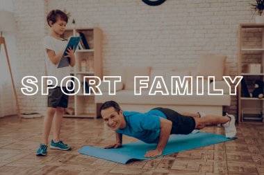 Baba gülümseyerek itme yapıyor Ups. Spor aile. Sağlıklı bir yaşam tarzı. Aktif tatil. Giysi uygular. İyiye gidiyor. Evde çalışma dışarı. Spor salonu halı. Uygulama yineleyin. Tablet sonuçlarına.