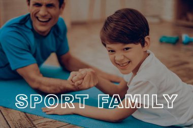 Baba ve oğul spor salonu yapıyoruz. Spor aile. Sağlıklı bir yaşam tarzı. Aktif tatil. Giysi uygular. İyiye gidiyor. Evde çalışma dışarı. Spor salonu halı. Uygulama tekrar. Bilek güreşi.