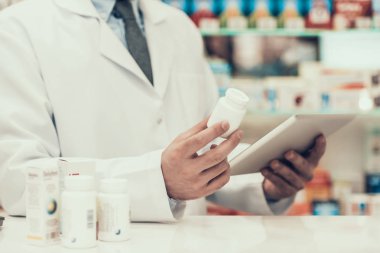Closeup Pharmacist Holding Pills Bottle and Tablet