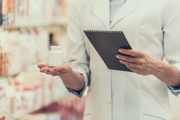 Närbild apotekspersonal innehar piller flaska och bärbara — Stockfoto