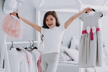 Küçük Sevimli Kız Yatak Odasında Bir Elbise Seçimi. Pretty Little Happy Girl Dolap Giysiler arasında Sneaking. Hayal Gücü veya Yaratıcılık Kavramı için Bir Clothesline Asılı Giyim Giyinmek.