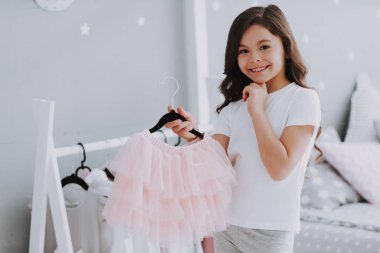 Küçük Sevimli Kız Yatak Odasında Bir Elbise Seçimi. Pretty Little Happy Girl Dolap Giysiler arasında Sneaking. Hayal Gücü veya Yaratıcılık Kavramı için Bir Clothesline Asılı Giyim Giyinmek.