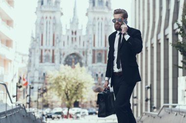 Yakışıklı İşadamı Cep Telefonu konuşuyor. Genç Kafkas Adam İş İş için Smartphone Holding. İş merkezinin yanında duran adam. İş Binası. Başarılı İşveren Bir Anlaşma yapmak için