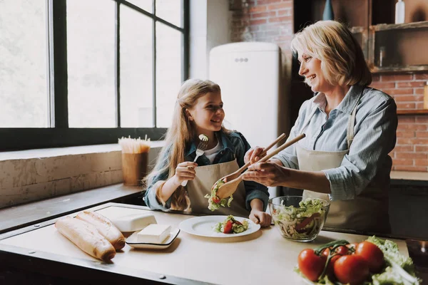 Cute Grandma and Granddaughter Cooking Salad. Grandma and Granddaughter Cooking Food. Vegetable Salad. Diet. Dieting Concept. Healthy Lifestyle. Cooking At Home. Prepare Food