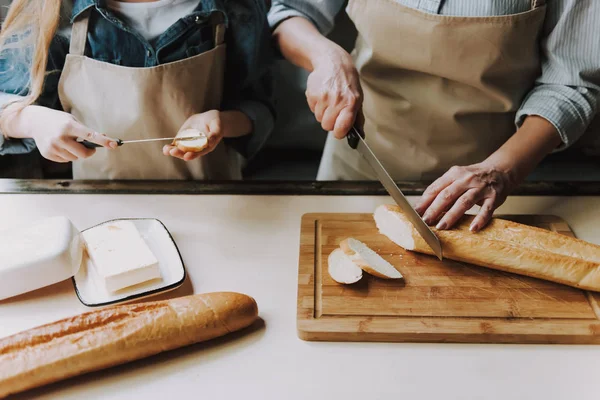 Close Senior Woman Hands Cutting Baguette Granddaughter Hands Holding Knife — Stock Photo, Image