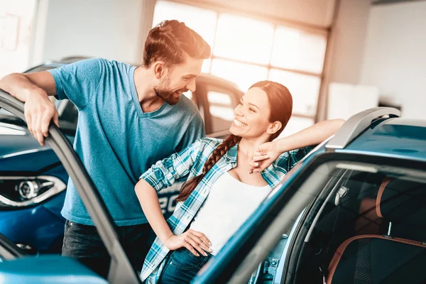 一个男人向女友展示一辆新车 目前的概念 凝视着对方 汽车沙龙 作出决定 门开着 结束交易 很好的报价 快乐在一起 成功购买 — 图库照片