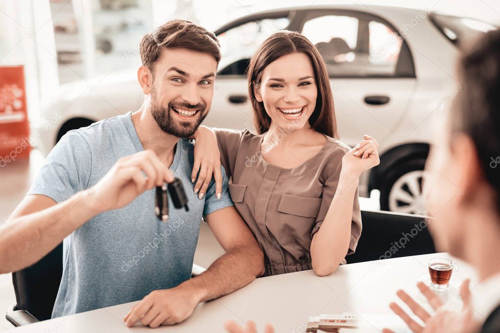 Showroom Dealer The Gives Car Keys To The Buyer. Dialogue With Dealer. Cheerful Customer. Automobile Salon. Make A Decision. End Of A Deal. Good Offer. Purchase Order. Happy Family.