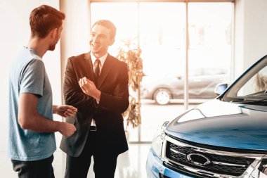 Adam ve satıcı showroom arabalar hakkında konuşun. Diyalog satıcı ile. Neşeli müşteri. Otomobil Salon. Karar verin. Bir anlaşma sona erdi. İyi bir teklif. Alıcı ve satıcı. İş Ticaret.