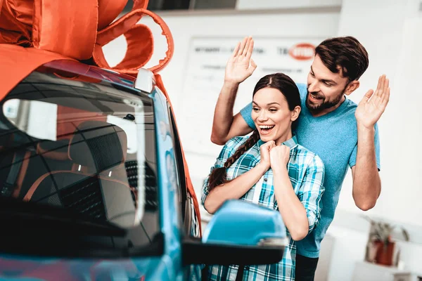 一个男人向女友展示一辆新车 目前的概念 凝视着对方 汽车沙龙 作出决定 礼品丝带 结束交易 很好的报价 快乐在一起 成功购买 — 图库照片