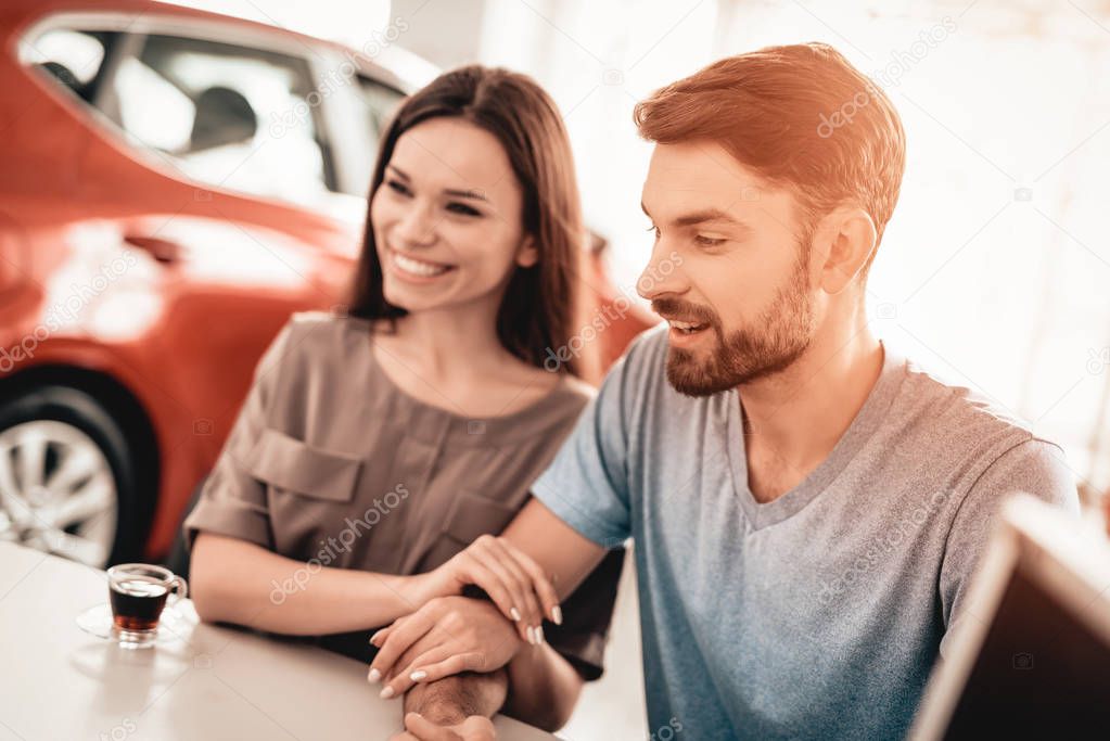 Happy Young Family Are Choosing A New Car In Showroom. Dialogue With Dealer. Automobile Salon. Make A Decision. Cup Of Coffee. End Of A Deal. Good Offer. New Buying. Business Trade.
