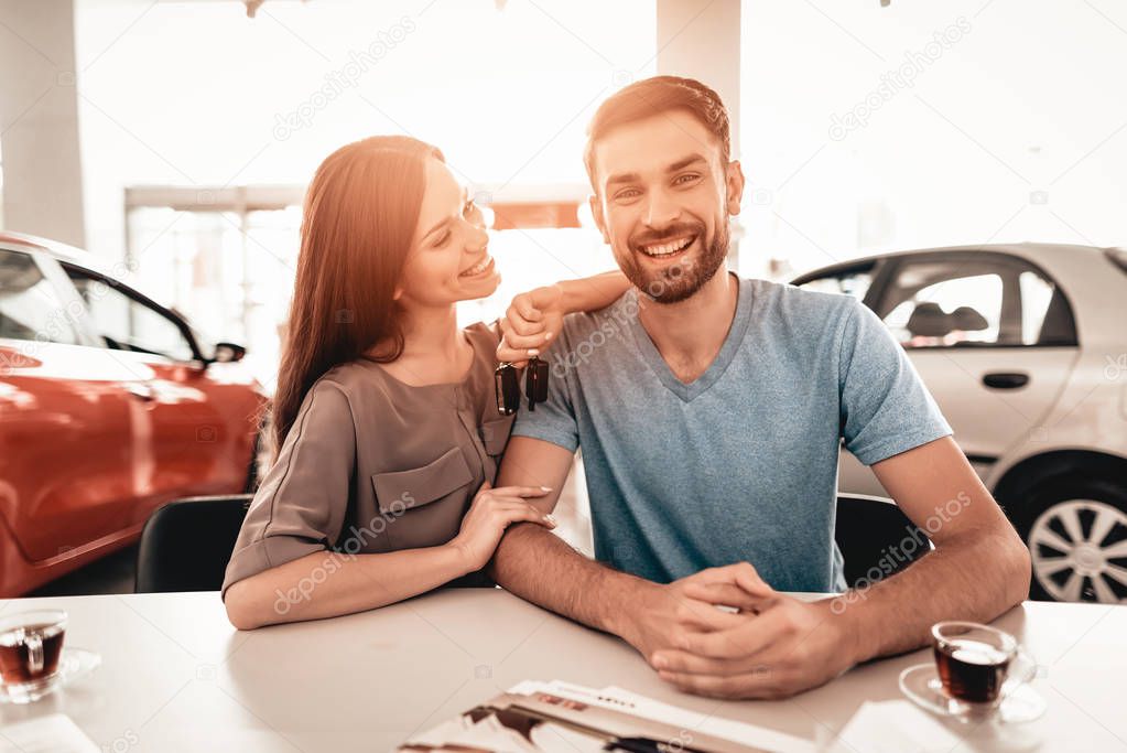 Happy Young Family Are Choosing A New Car In Showroom. Dialogue With Dealer. Automobile Salon. Make A Decision. Cup Of Coffee. End Of A Deal. Good Offer. New Buying. Business Trade.