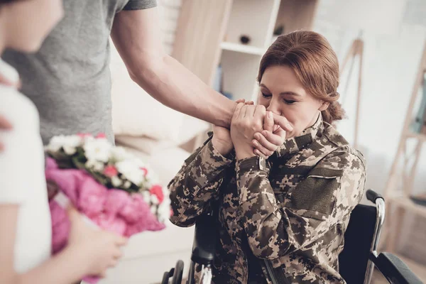Woman Veteran In Wheelchair Homecoming Concept. Family Meeting. Son And Husband. Embrace With Mother. Camouflage Uniform. Child Hanging. Flowers Bouquet. Patriotic Comeback. Paralyzed Soldier.