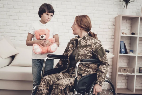 坐在轮椅上的女性退伍军人回家观念 家庭会议 离开战争蓬松的玩具 伪装制服 儿子吊着感觉显示 爱国回归 瘫痪士兵 — 图库照片