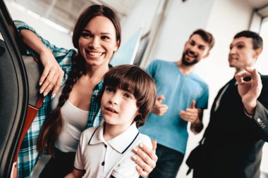 Mutlu genç aile galeride yeni bir otomatik tercih ediyor. Diyalog satıcı ile. Neşeli müşteri. Gövde içinde bak. Karar verin. İyi bir teklif. Alıcı ve satıcı. İş Ticaret.