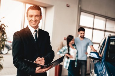 Araba satıcısı kamera arka plan üzerinde bir alıcı ile poz. Neşeli müşteri. Otomobil Salon. Karar verin. Bir anlaşma sona erdi. İyi bir teklif. Yeni satın alma. İş Ticaret. Kendine güvenen satıcı. Satınalma siparişi.