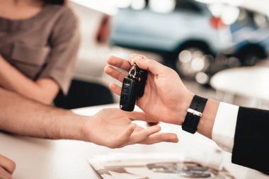 Showroom satıcı alıcı verir araba anahtarları.