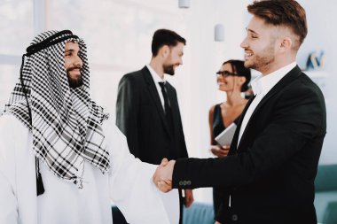 Arap işadamı bir Yöneticisi ile bir el sıkışma var. Para yatırım. Meslektaşları ile konuşuyor. Ortaklık Anlaşması. Disdash ve Keffiyeh giyiyor. Bir anlaşma sona erdi. İş tartışma.