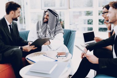 Arap İşadamı Ortakları ile Buluşma Toplantısı. Para Yatırımı. Kağıt Belgeler. İş Stratejisi. Ortaklık Anlaşması. Disdash ve Keffiyeh Giyiyor. Dizüstü Bilgisayar ile Çalışma.