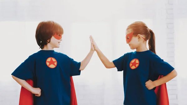Children In A Superhero Suits. Posing Concept. Masks And A Raincoats. Bright Room. Resting Together. Save The World. Get Ready. High Five. Happy Childhood. Brother And Sister. Young Leaders.