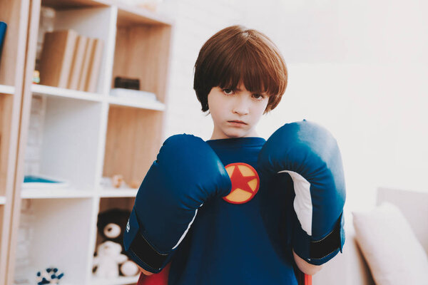 A Little Dark-haired Boy In A Superhero Shirt. Kid In A Boxing Gloves. Time For Action. Double Life. Alter Ego. Ger Ready. Strong And Powerful. Hidden Personality. Confidence And Bravery.