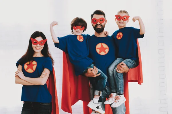年轻的家庭在超级英雄西装 摆造型的概念 口罩和雨衣 明亮的客房 在一起休息 拯救世界 准备好 手牵手 有父母的孩子积极的生活方式 — 图库照片
