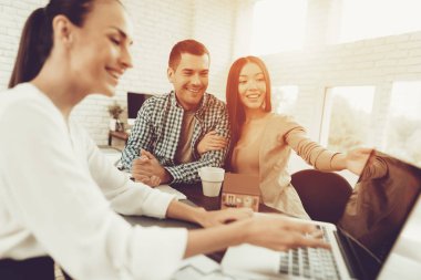Emlakçı ofisinde gülümseyen kadın ve genç erkek. Ahşap masa planı. Emlak kavramları. Genç bir çift. Yeni ev satın alma. Office ailesi. Kiralık Ajan kavramı. Mutlu bir aile.
