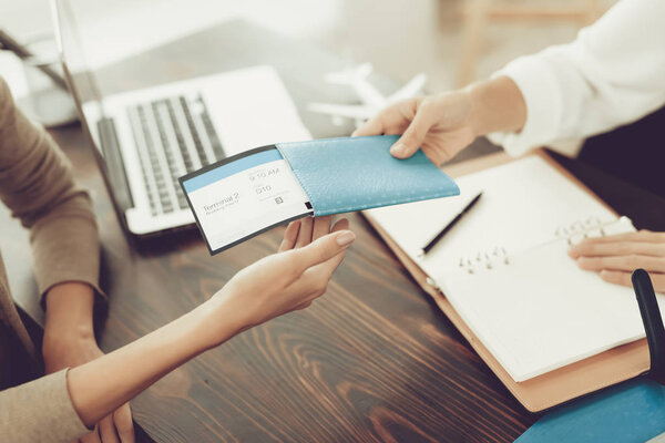Young Woman in Travel Agency Buying Tickets .