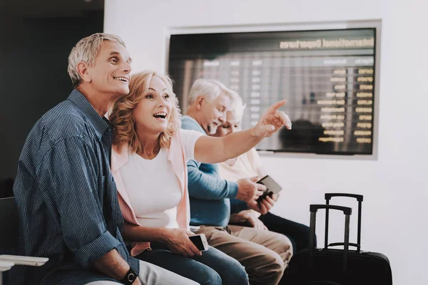 待合室で空港でバッグを持つ古いカップル 空港で上級者は 観光概念 航海の老夫婦 空港ターミナル 年金受給者のための休暇 荷物を持つ人々 休暇の旅行者 — ストック写真