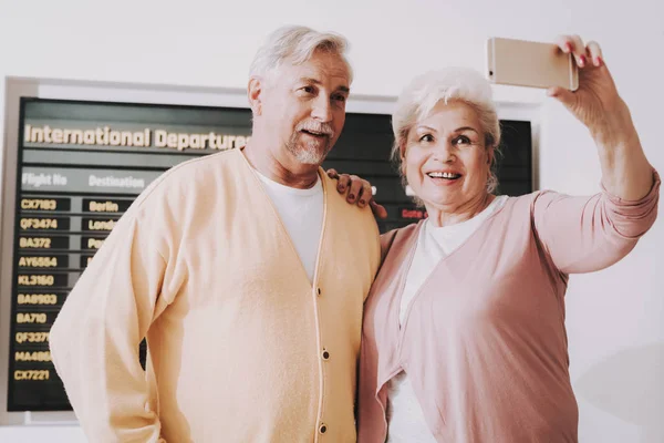 古いカップルは待合室で空港で写真を撮影 空港で上級者は 観光概念 航海のカップル 空港ターミナル 年金受給者のための休暇 荷物を持つ人々 休暇の旅行者 — ストック写真