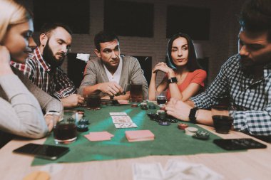 Genç arkadaşlar evde parti poker oynamak. Oyun oynamayı. Kapalı eğlenceli. Genç kız. Genç bir adam. Masada oturuyor. Arkadaş grubu parti. Kapalı faaliyetleri kavramı. Kumar. Kart oyunları.