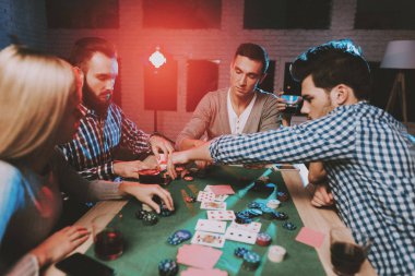 Genç arkadaşlar evde parti poker oynamak. Oyun oynamayı. Kapalı eğlenceli. Genç kız. Genç bir adam. Masada oturuyor. Arkadaş grubu parti. Kapalı faaliyetleri kavramı. Kumar. Kart oyunları.