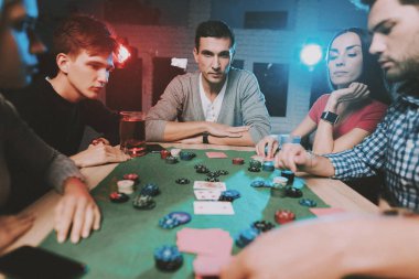 Genç arkadaşlar evde parti poker oynamak. Oyun oynamayı. Kapalı eğlenceli. Genç kız. Genç bir adam. Masada oturuyor. Arkadaş grubu parti. Kapalı faaliyetleri kavramı. Kumar. Kart oyunları.