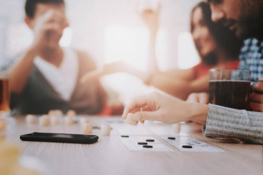 Genç gülümseyen insanlar eğlenceli evde parti var. Oyun oynamayı. Abur cubur yeme. Kapalı eğlenceli. Genç gülümseyen kız. Genç gülümseyen adam. Masada oturuyor. Arkadaş grubu parti. Kapalı faaliyetleri kavramı.