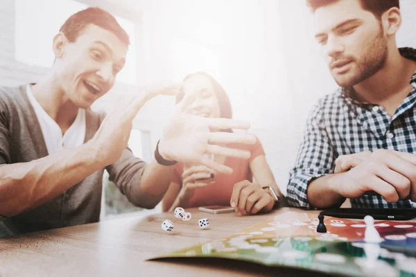 Young Smiling People Have Fun on Party at Home. Playing Games. Eating Snacks. Indoor Fun. Young Smiling Girl. Young Smiling Guy. Sitting at Table. Party with Friends. Indoor Activities Concept.