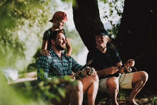 息子と夏の川の父釣りと若い男 屋外リラックス 老人と少年 湖の近くの男性 手の釣り竿 夏のスポーツ 川の週末 高齢者の漁師 — ストック写真