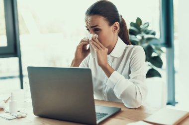 Genç kadın Office.Healthcare kavramı içinde oturan beyaz gömlekli hasta. Modern ofis. Hasta işçi. Office sağlık hizmeti. Ahşap masa. Dijital aygıt. Laptop üstünde okul sırası. Ofiste genç kadın.