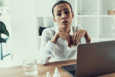 Young Sick Woman in White Shirt Sitting in Office.Healthcare Concept. Modern Office. Sick Worker. Healthcare in Office. Wooden Table. Digital Device. Laptop on Desk. Young Woman in Office. clipart