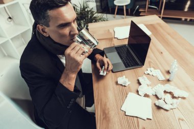 Hasta adam ofiste oturan eşarp ile takım elbiseli. Modern Ofis Yöneticisi. Sağlık kavramı. Modern ofis. Hasta işçi. Office sağlık hizmeti. Ahşap masa. Dijital aygıt. Resepsiyon üstünde Laptop.