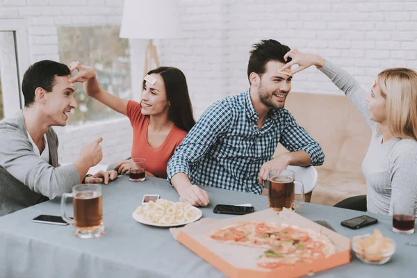 Young Smiling People Have Fun on Party at Home. Playing Games. Eating Snacks. Indoor Fun. Young Smiling Girl. Young Smiling Guy. Sitting at Table. Party with Friends. Indoor Activities Concept.