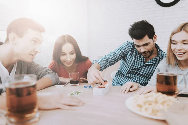 Young Smiling People Have Fun on Party at Home. Playing Games. Eating Snacks. Indoor Fun. Young Smiling Girl. Young Smiling Guy. Sitting at Table. Party with Friends. Indoor Activities Concept.