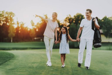 Mutlu genç aile yaz aylarında Golf sahasında rahatla. Golf Club civarındaki rahatlatıcı. Spor yaz. Yaz aylarında açık eğlenceli. Aile eğlencesi. Sağlıklı yaşam konsepti. Küçük kız. Yeşil çimen.