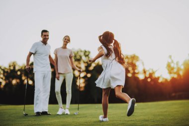 Mutlu genç aile yaz aylarında Golf sahasında rahatla. Golf Club civarındaki rahatlatıcı. Spor yaz. Yaz aylarında açık eğlenceli. Aile eğlence kavramı. Sağlıklı yaşam konsepti. Küçük kız. Yeşil çimen.
