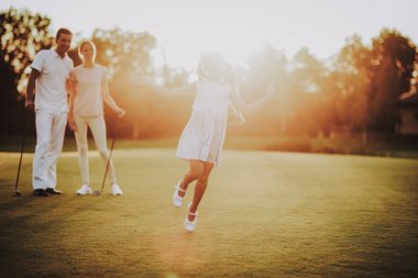 Mutlu genç aile yaz aylarında Golf sahasında rahatla. Golf Club civarındaki rahatlatıcı. Spor yaz. Yaz aylarında açık eğlenceli. Aile eğlence kavramı. Sağlıklı yaşam konsepti. Küçük kız. Yeşil çimen.