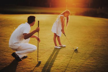 Mutlu genç aile yaz aylarında Golf sahasında rahatla. Golf Club civarındaki rahatlatıcı. Spor yaz. Yaz aylarında açık eğlenceli. Aile eğlence kavramı. Sağlıklı yaşam konsepti. Küçük kız. Yeşil çimen.