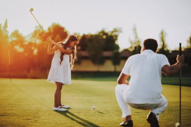 Mutlu genç aile yaz aylarında Golf sahasında rahatla. Golf Club civarındaki rahatlatıcı. Spor yaz. Yaz aylarında açık eğlenceli. Aile eğlence kavramı. Sağlıklı yaşam konsepti. Küçük kız. Yeşil çimen.
