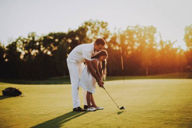 Baba küçük kızı ile golf sahasında oynuyor... Golf Club civarındaki rahatlatıcı. Spor yaz. Yaz aylarında açık eğlenceli. Aile eğlencesi. Sağlıklı yaşam konsepti. Küçük kız. Yeşil çimen.