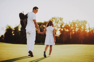 Baba küçük kızı ile golf sahasında oynuyor... Golf Club civarındaki rahatlatıcı. Spor yaz. Yaz aylarında açık eğlenceli. Aile eğlencesi. Sağlıklı yaşam konsepti. Küçük kız. Yeşil çimen.